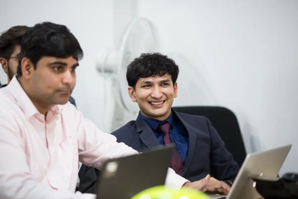 Two colleagues sharing a laugh at their desks