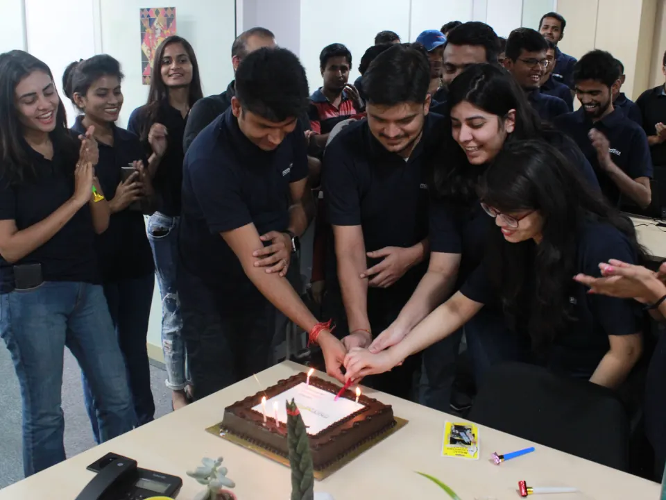 The team cutting a cake together