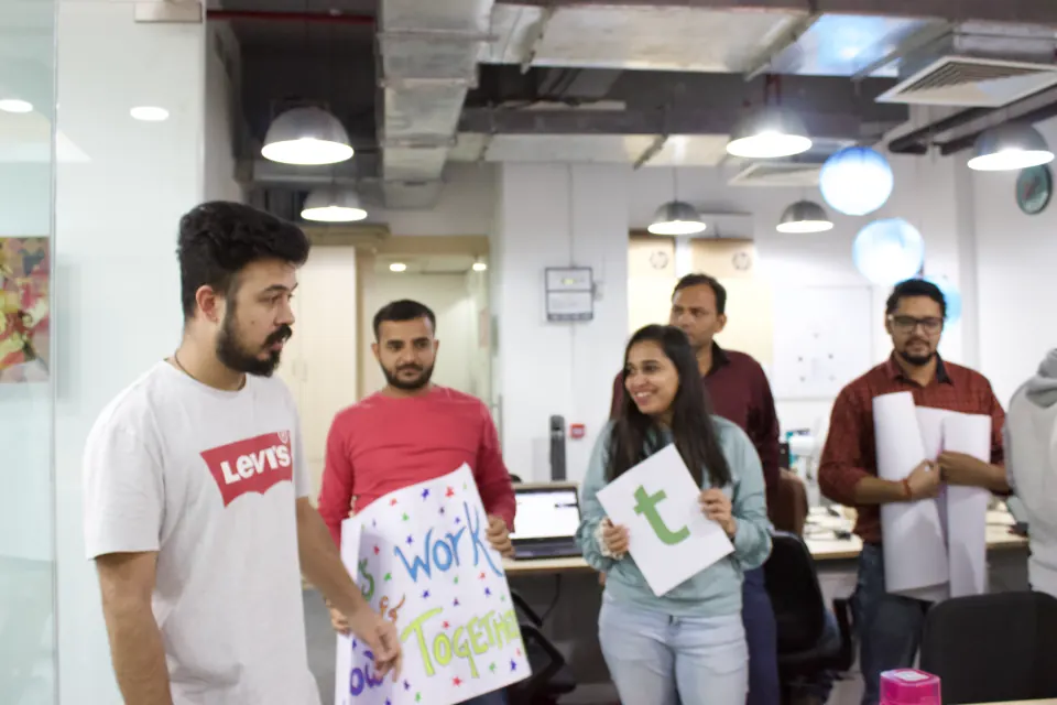 Team members holding up letters and posters