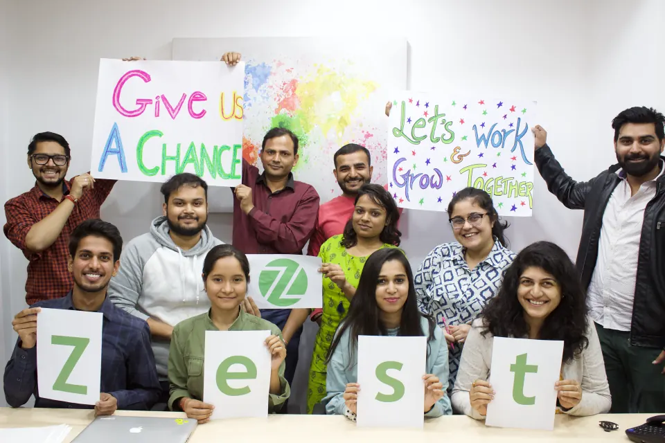 Team members spelling out a sign, holding cards and posters