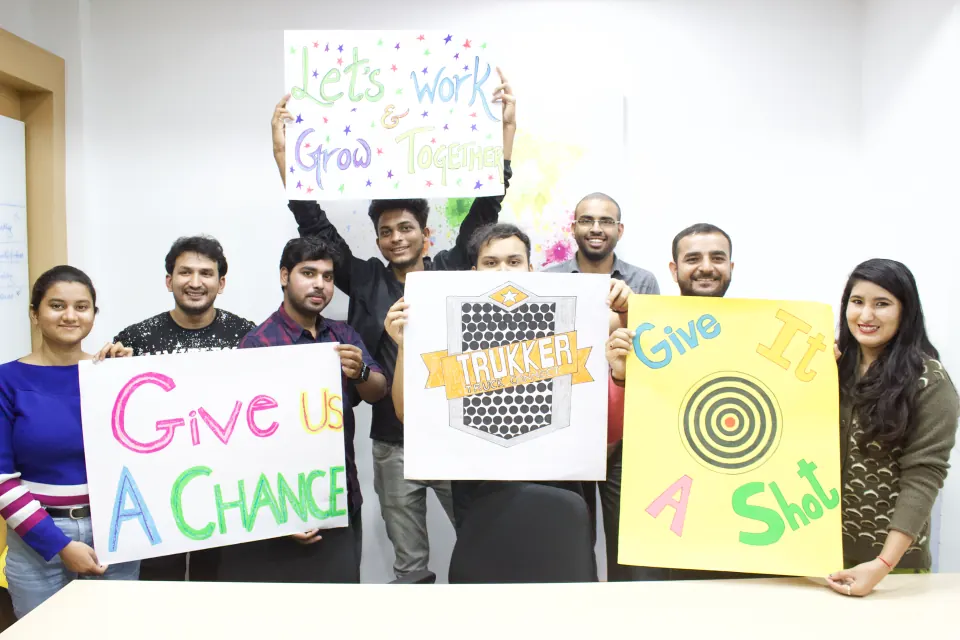Team members holding up hand-made posters