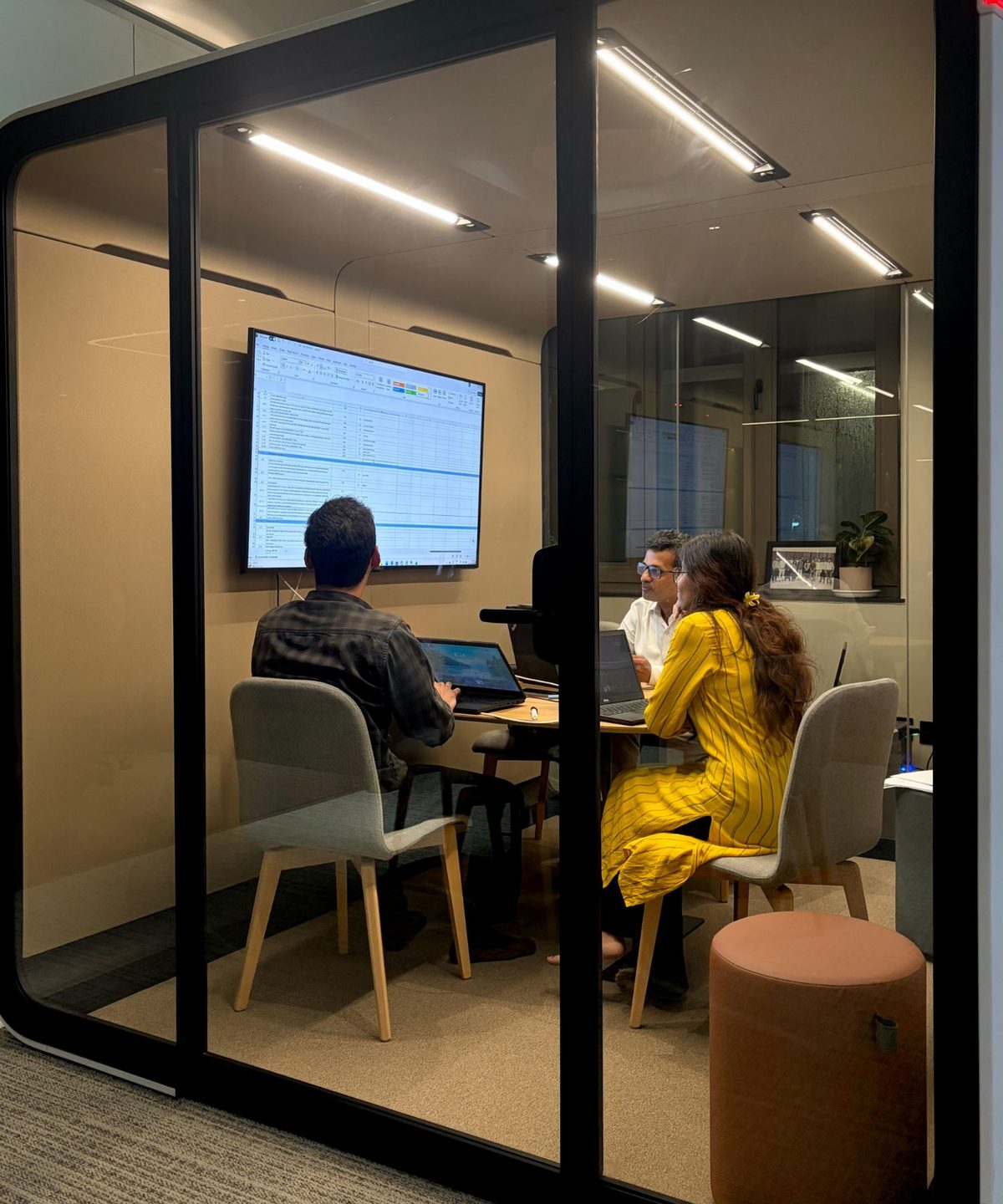 MoreTasks colleagues reviewing a client’s workflow on screen in a meeting pod