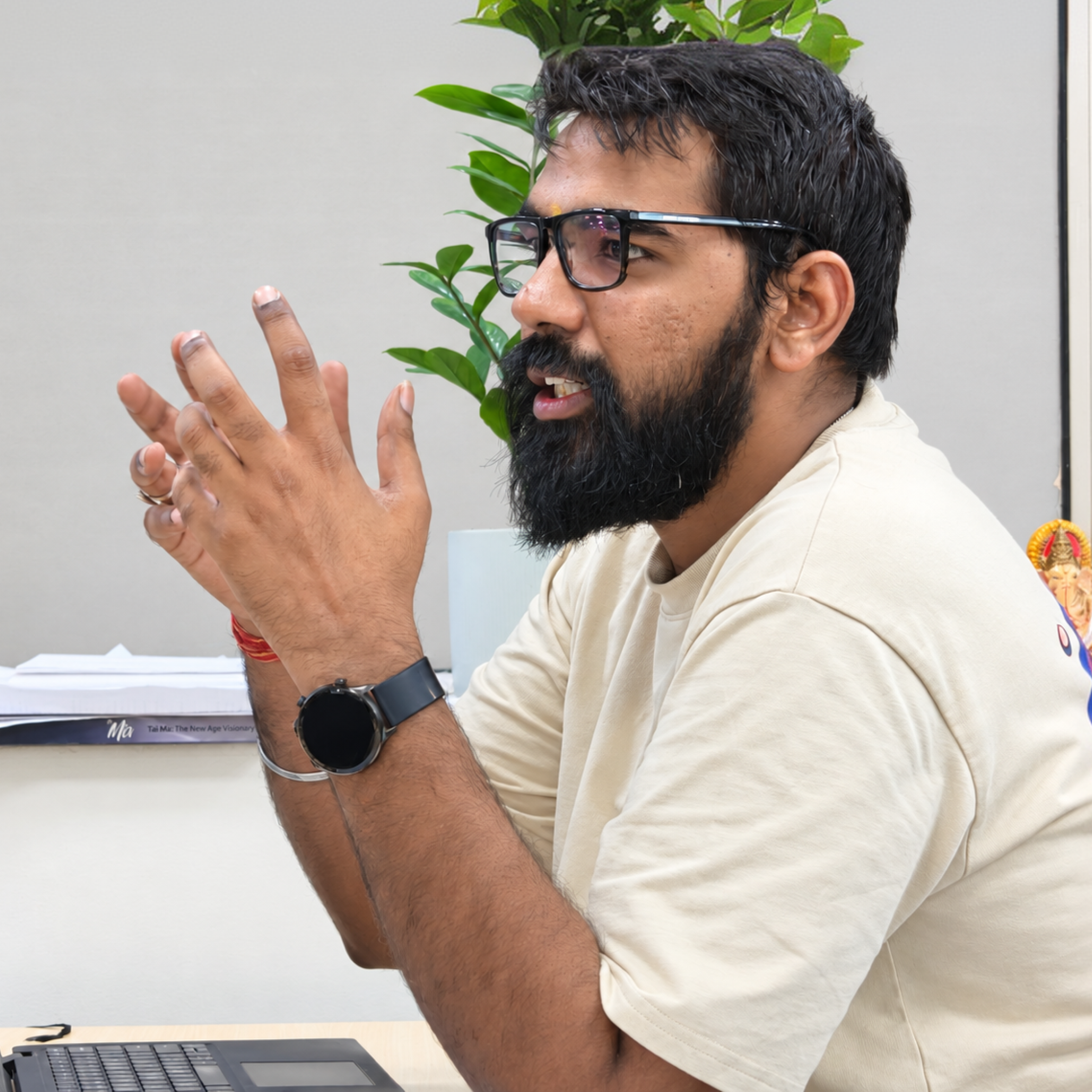 A MoreTasks colleague talking through a task at his desk, hands mid-gesture